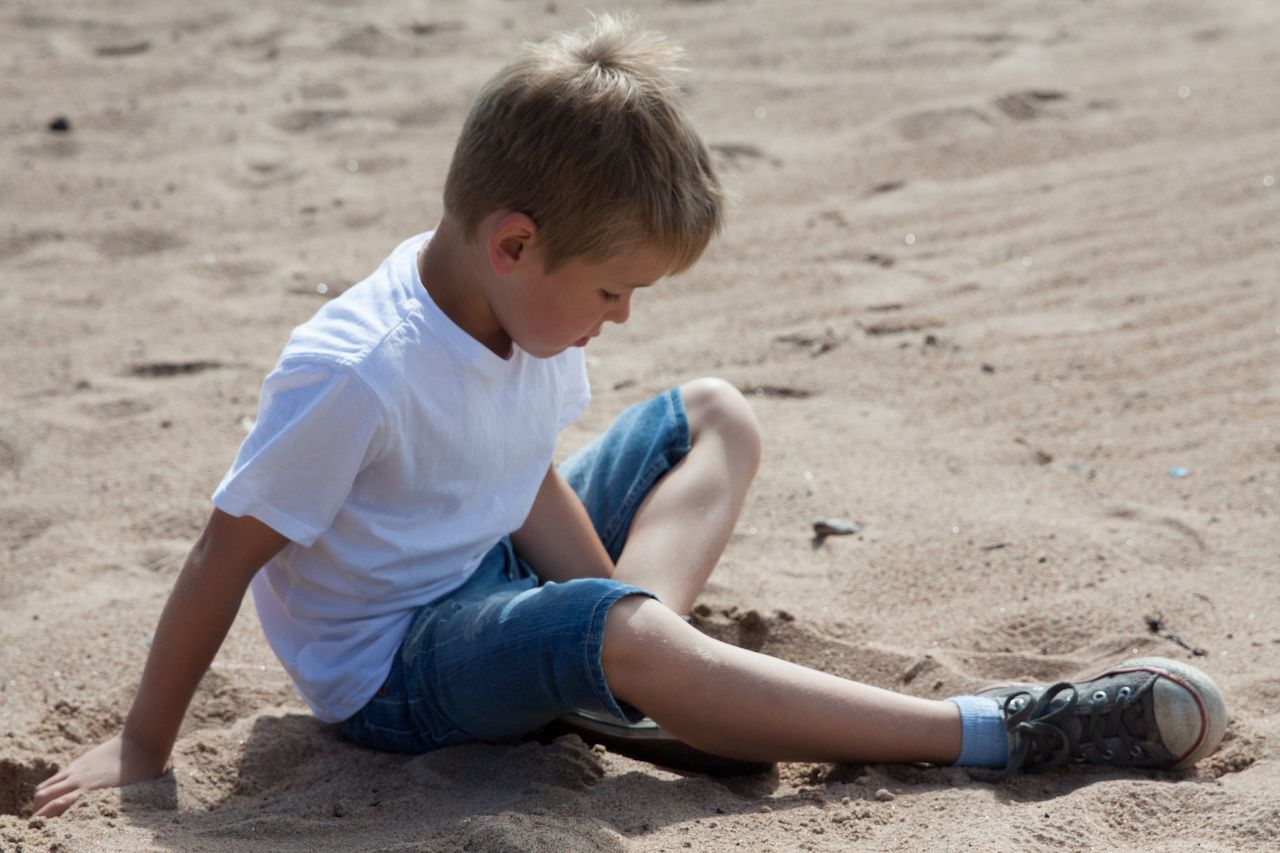 boy-sitting-sand-beach.jpg