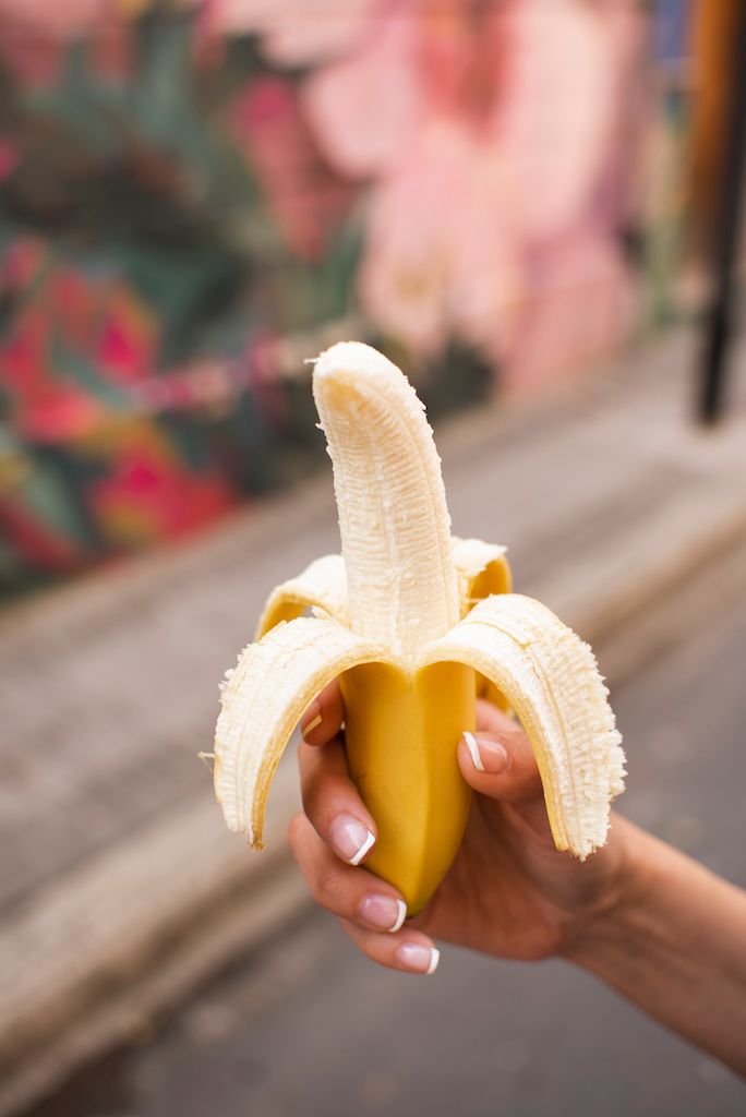 close-up-woman-holding-up-banana.jpg