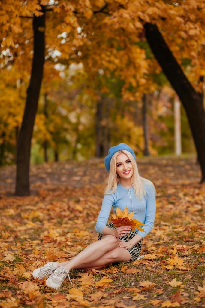 free-photo-of-smiling-blonde-woman-sitting-at-park-in-autumn.jpeg