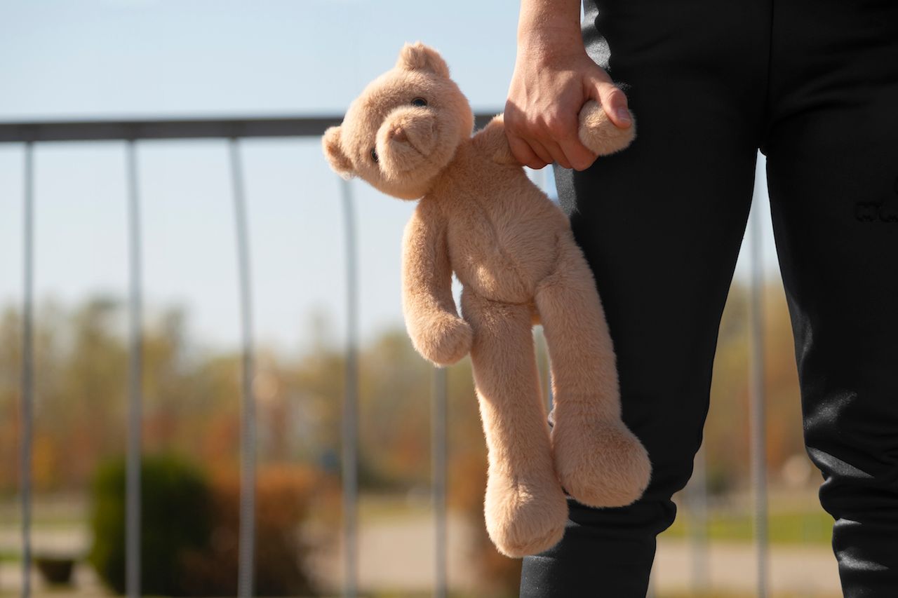 front-view-kid-holding-teddy-bear-outdoors.jpg