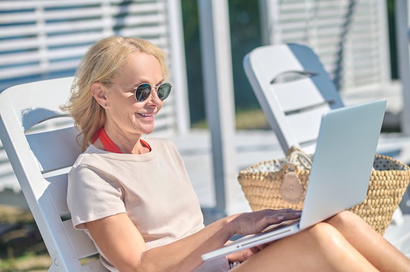 good-looking-blonde-woman-with-laptop-sitting-chaise-lounge.jpg