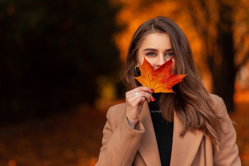 happy-beautiful-woman-fashionable-beige-coat-sweater-covers-her-face-with-colored-autumn-leaf-park-with-orange-fall-foliage-space-text_338491-12570.jpg