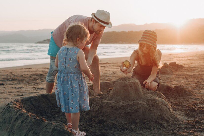 happy-family-having-fun-together-beach-sunset-building-sand-castle_8353-8336.jpg