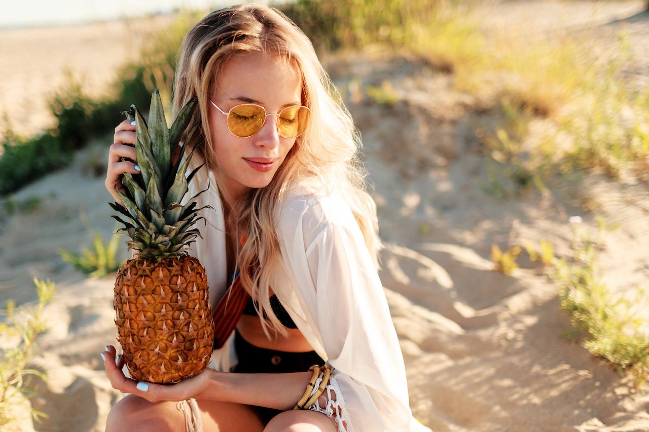 lifestyle-outdoor-picture-laughing-pretty-woman-with-juicy-pineapple-relaxing-sunny-beach-trendy-summer-outfit.jpg