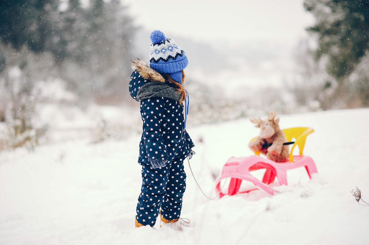 little-girl-blue-hat-playing-winter-forest.jpg