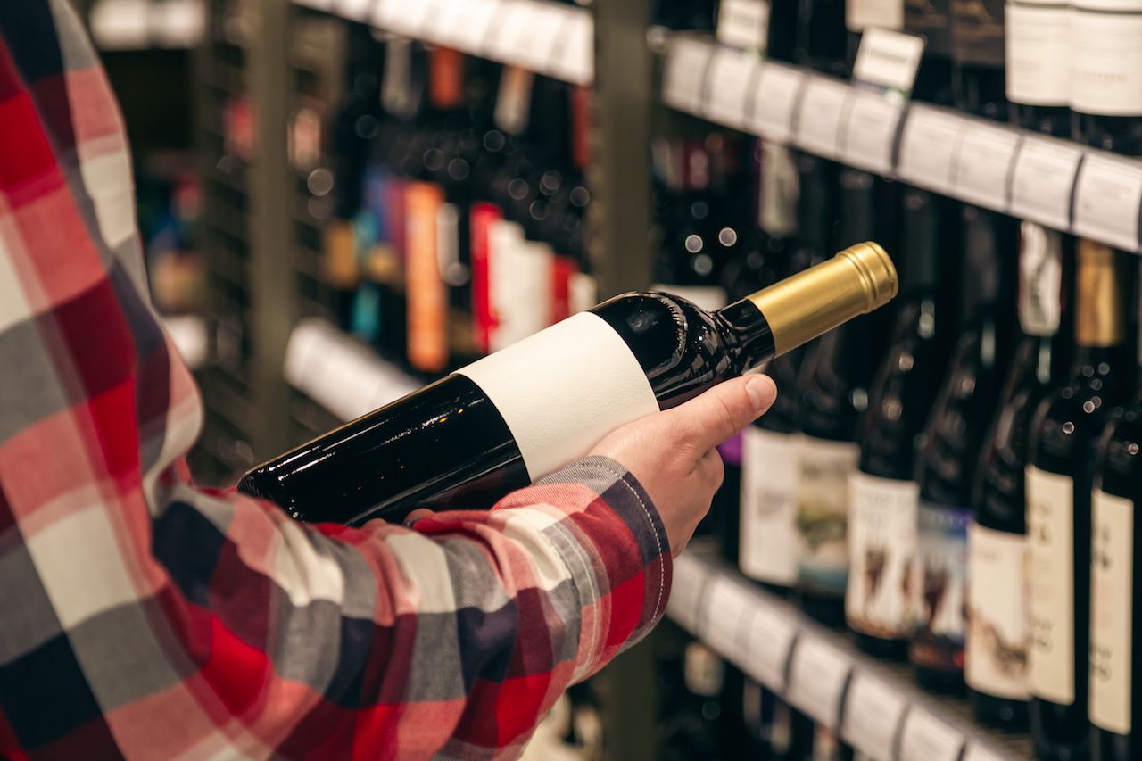 male-customer-holding-bottle-red-wine-close-up.jpg