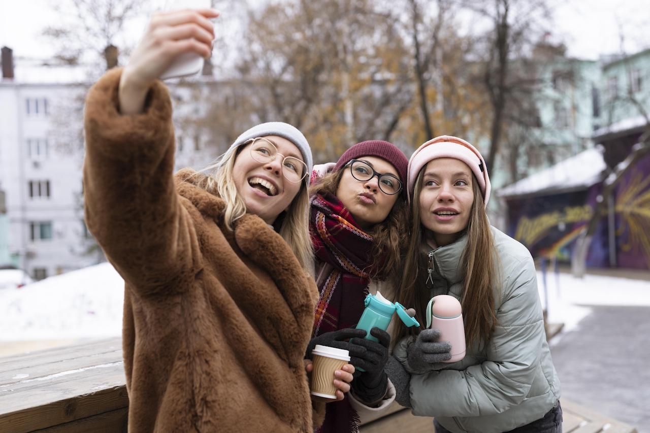 medium-shot-friends-taking-selfies.jpg