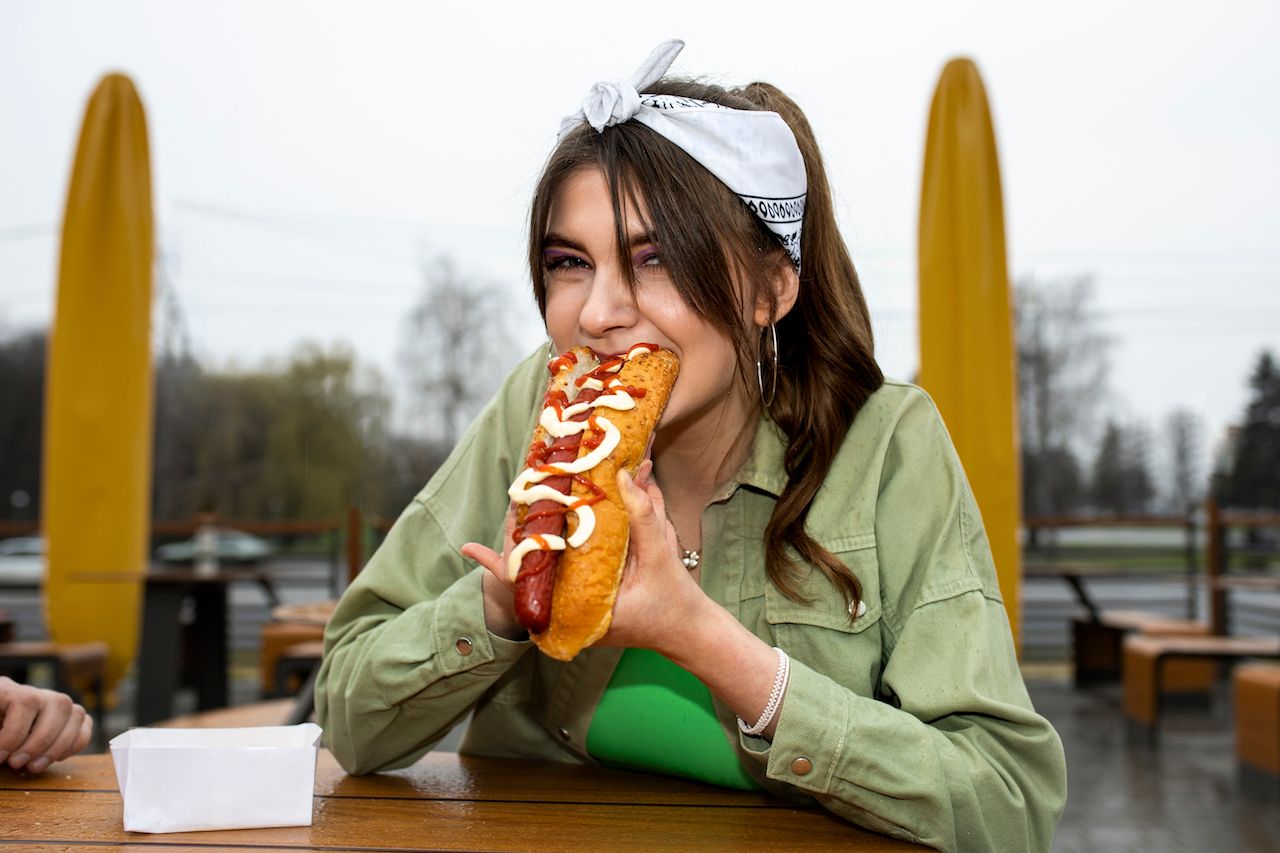 medium-shot-woman-with-delicious-hot-dog.jpg