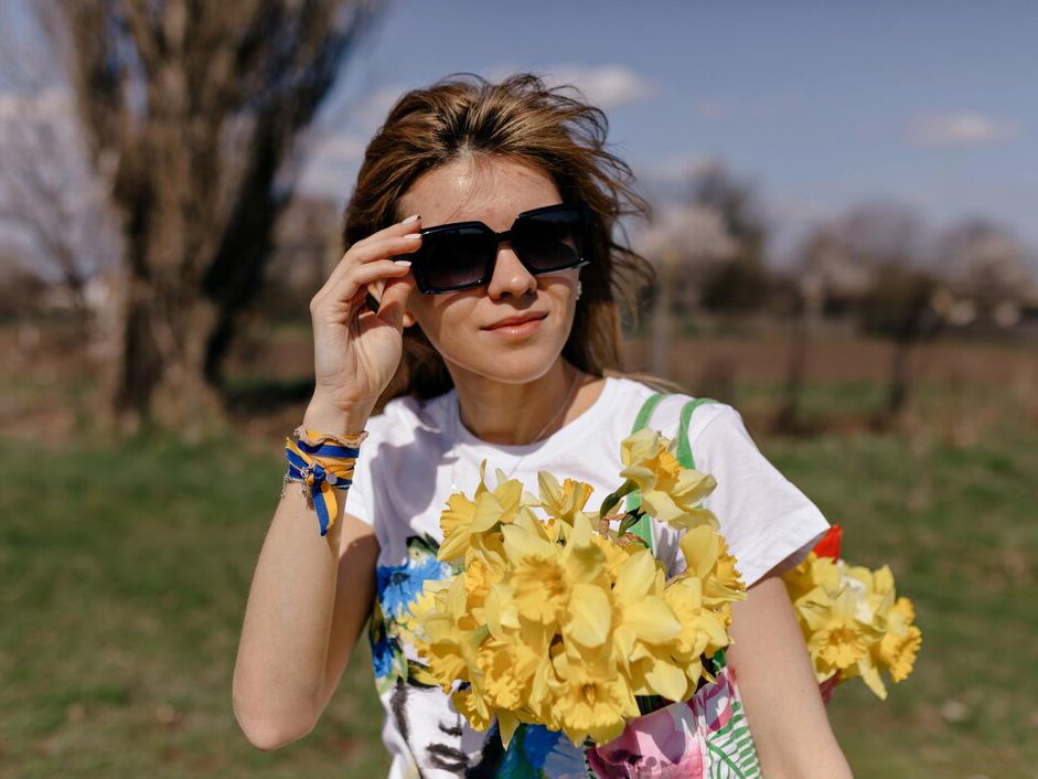 outdoor-portrait-stylish-ukrainian-woman-with-flying-hair-wearing-sunglasses-holding-bag-with-wonderful-yellow-flowers_291650-2486.jpg