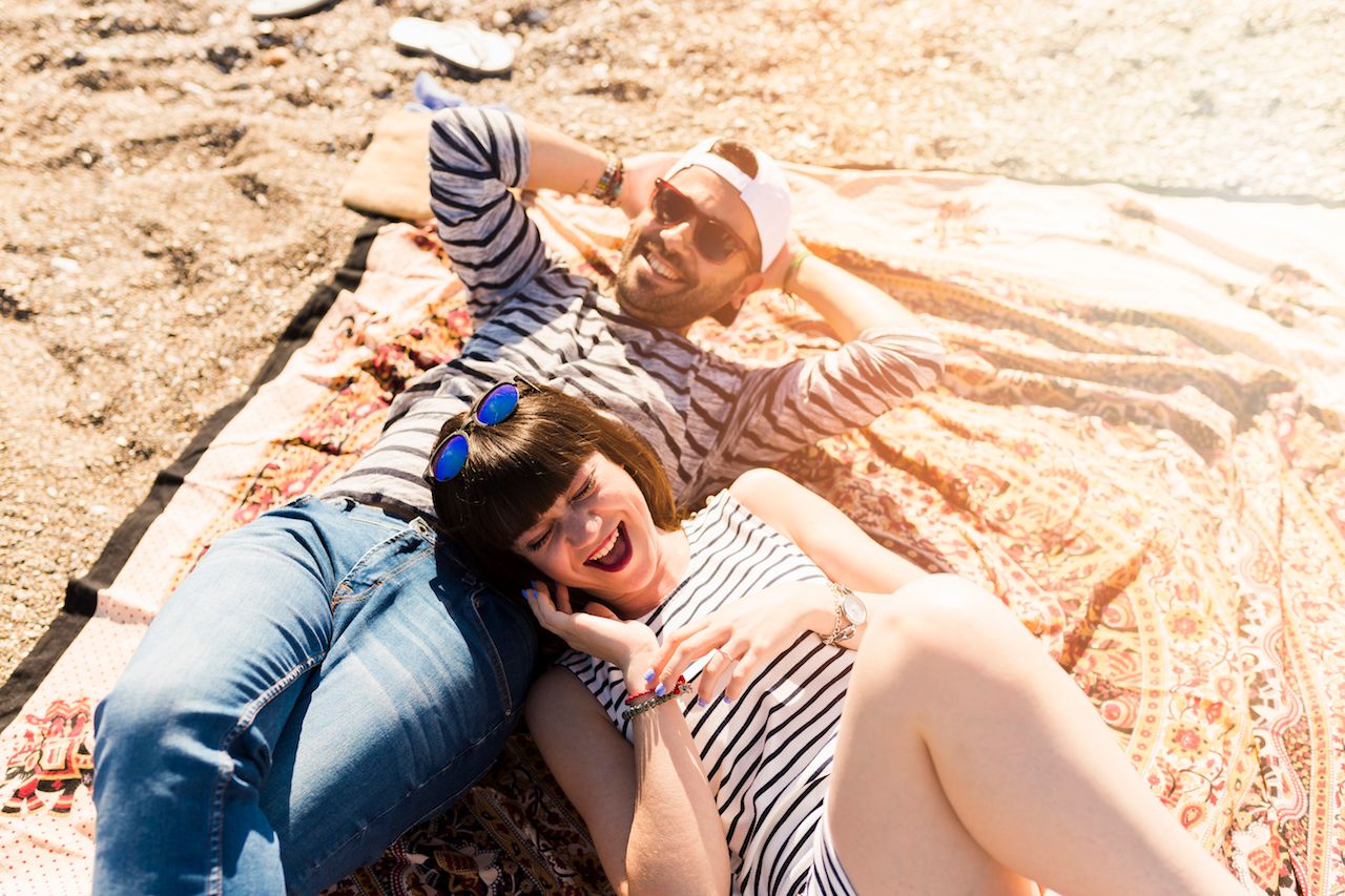 overhead-view-couple-lying-blanket-beach.jpg