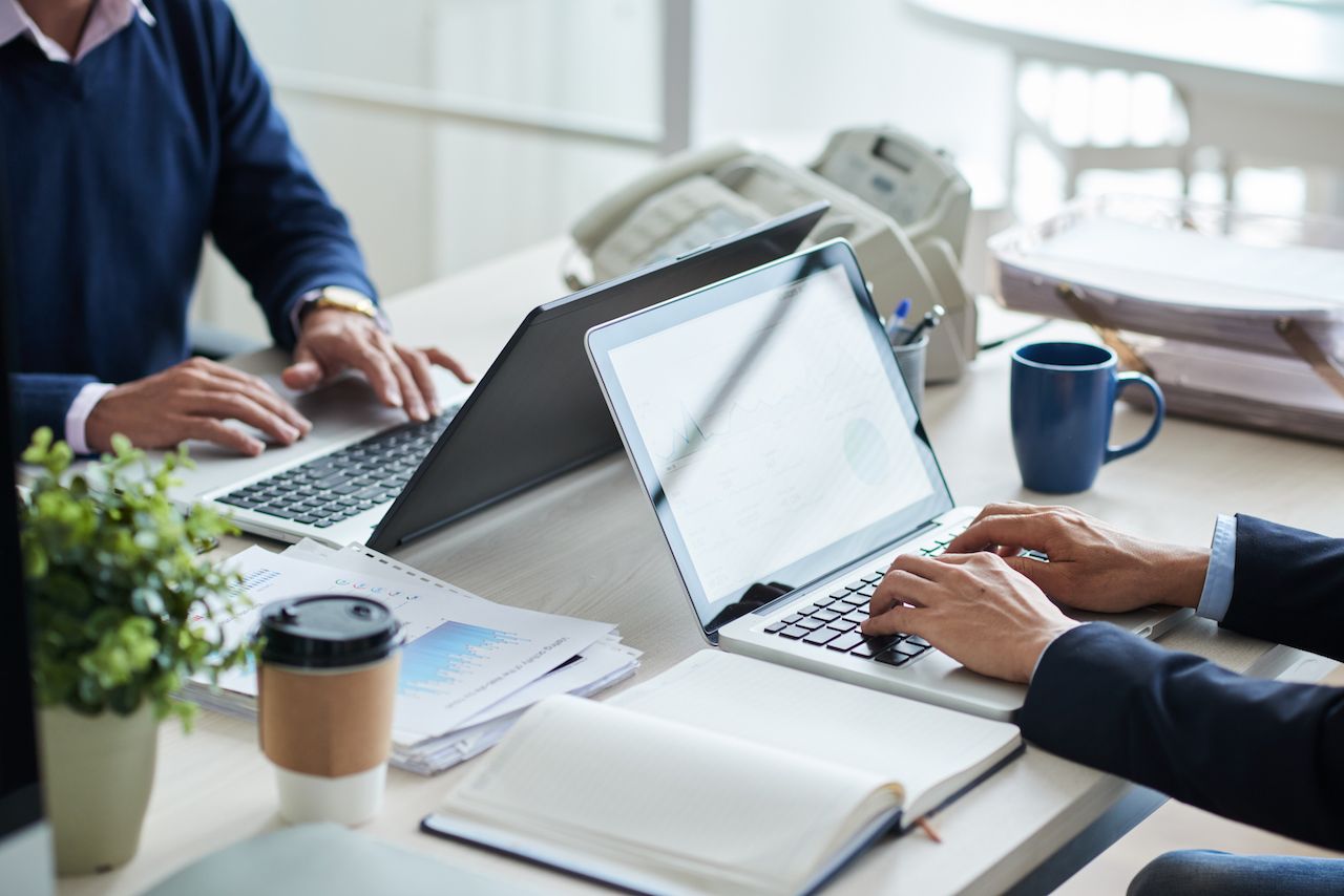 side-view-cropped-unrecognizable-business-people-working-common-desk.jpg