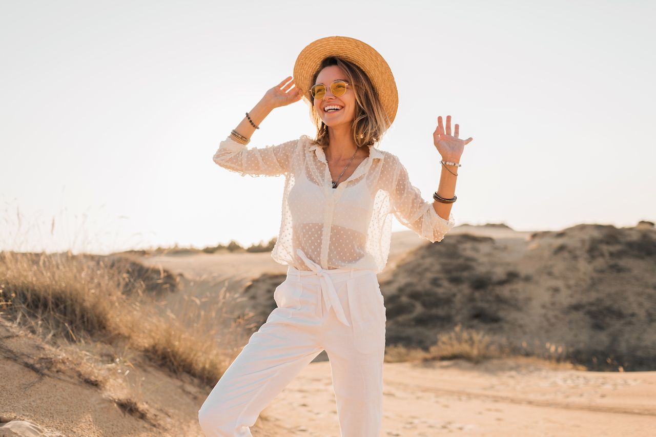stylish-happy-beautiful-smiling-woman-posing-desert-sand-white-outfit-wearing-straw-hat-sunglasses-sunset.jpg