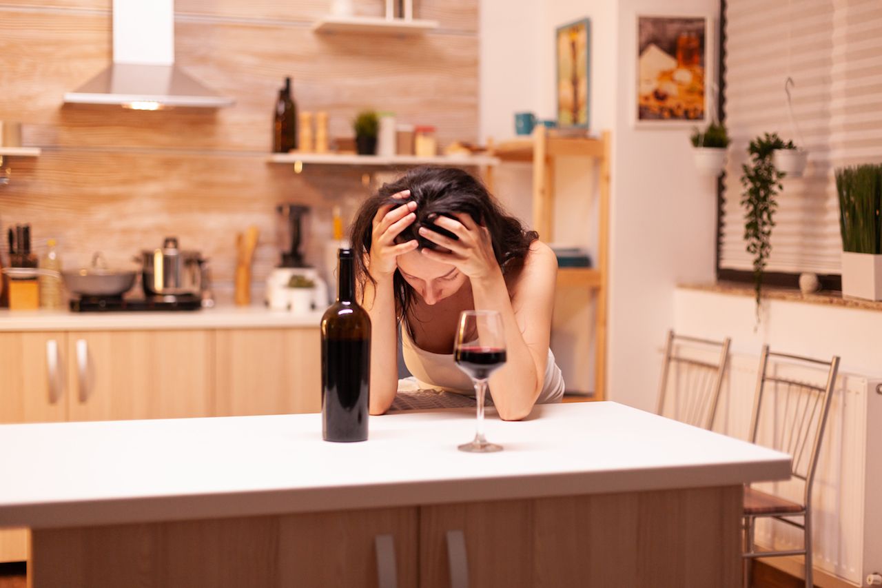 woman-with-alcoholic-beverage-is-drinking-alone-bottle-wine-that-get-her-hangover.jpg