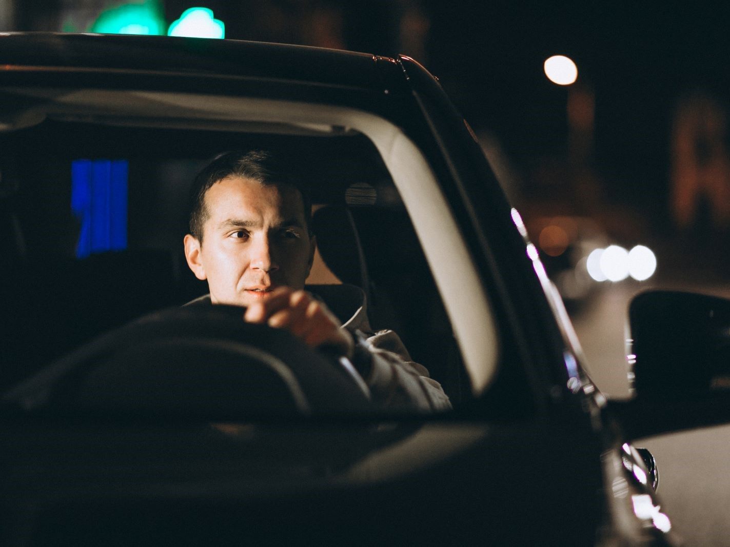 young-man-driving-his-car-night-time.jpg