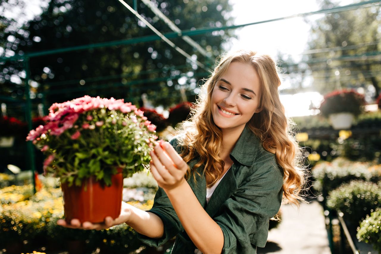 young-woman-with-beautiful-blond-hair-gentle-smile-dressed-green-robe-with-belt-is-working-greenhouse.jpg